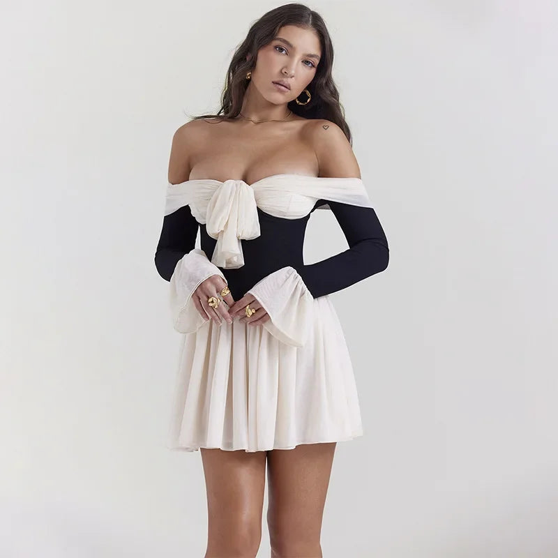 Contrasterende jurk met strik voor en off-the-shoulder design