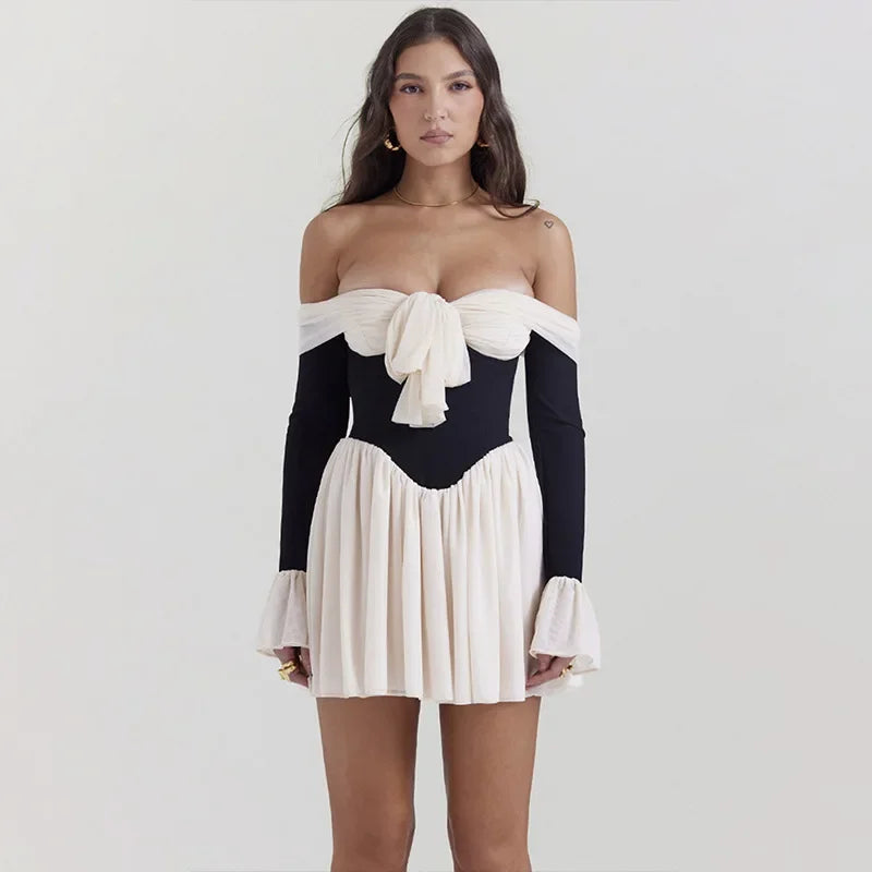 Contrasterende jurk met strik voor en off-the-shoulder design